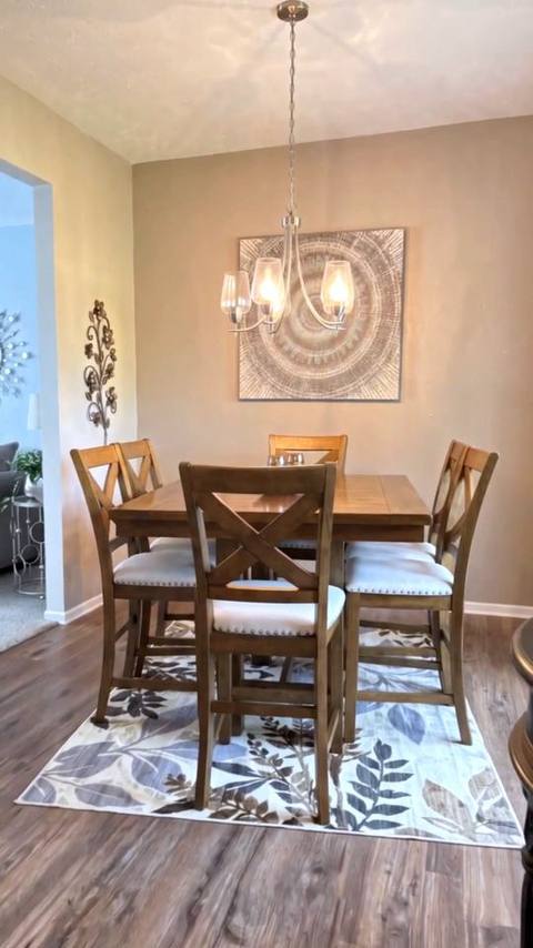 Vertical frame from the reel: the same dining room, same table, chairs, chandelier and wall art