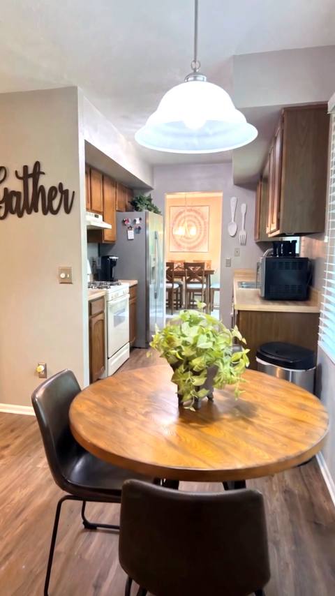 Vertical frame from the reel: the same breakfast nook and Gather sign, looking down the galley kitchen